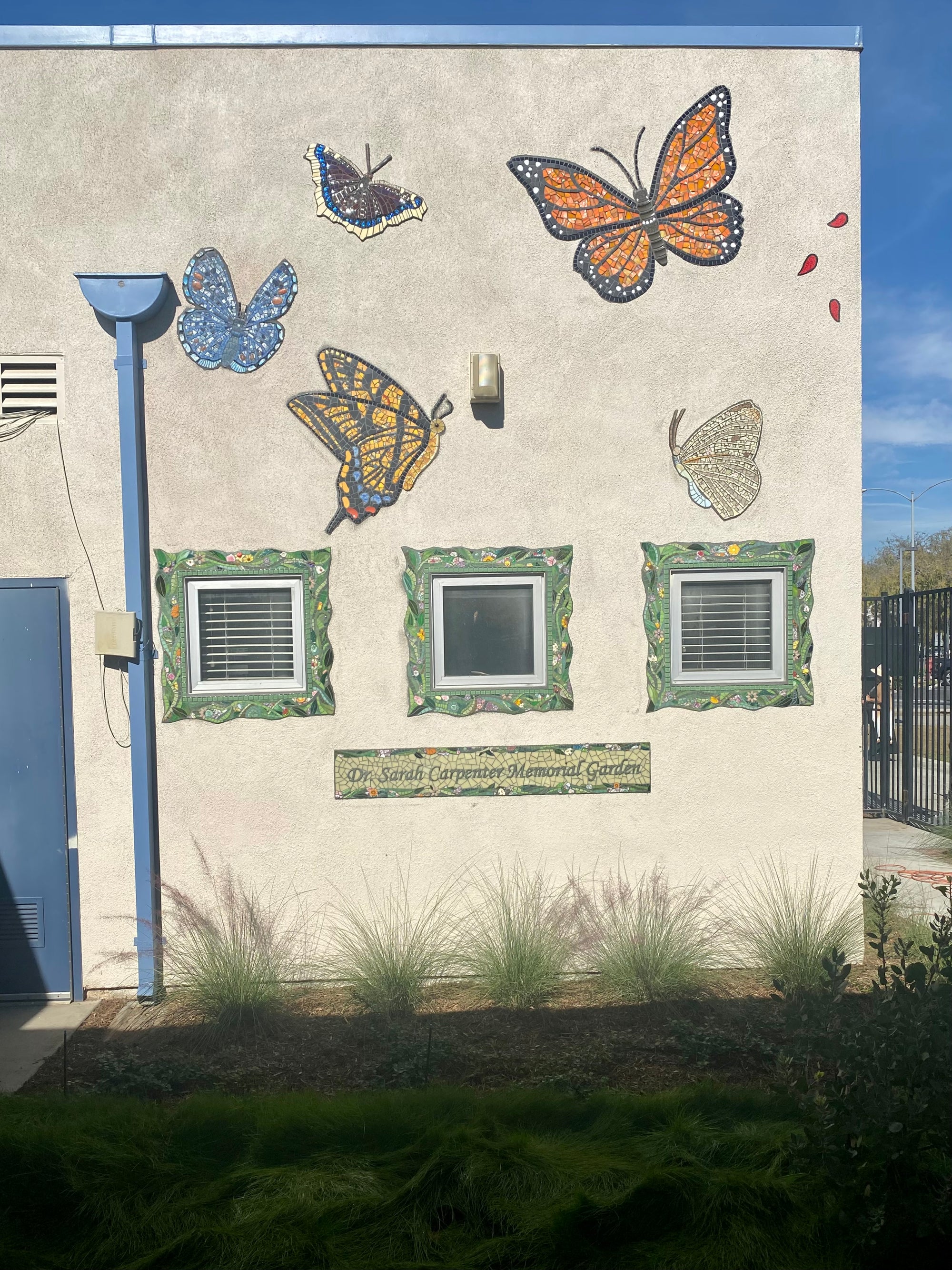 Large mosaic butterflies on the side of a building.