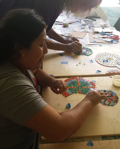 Artist working on a mosaic at a Piece by Piece workshop.