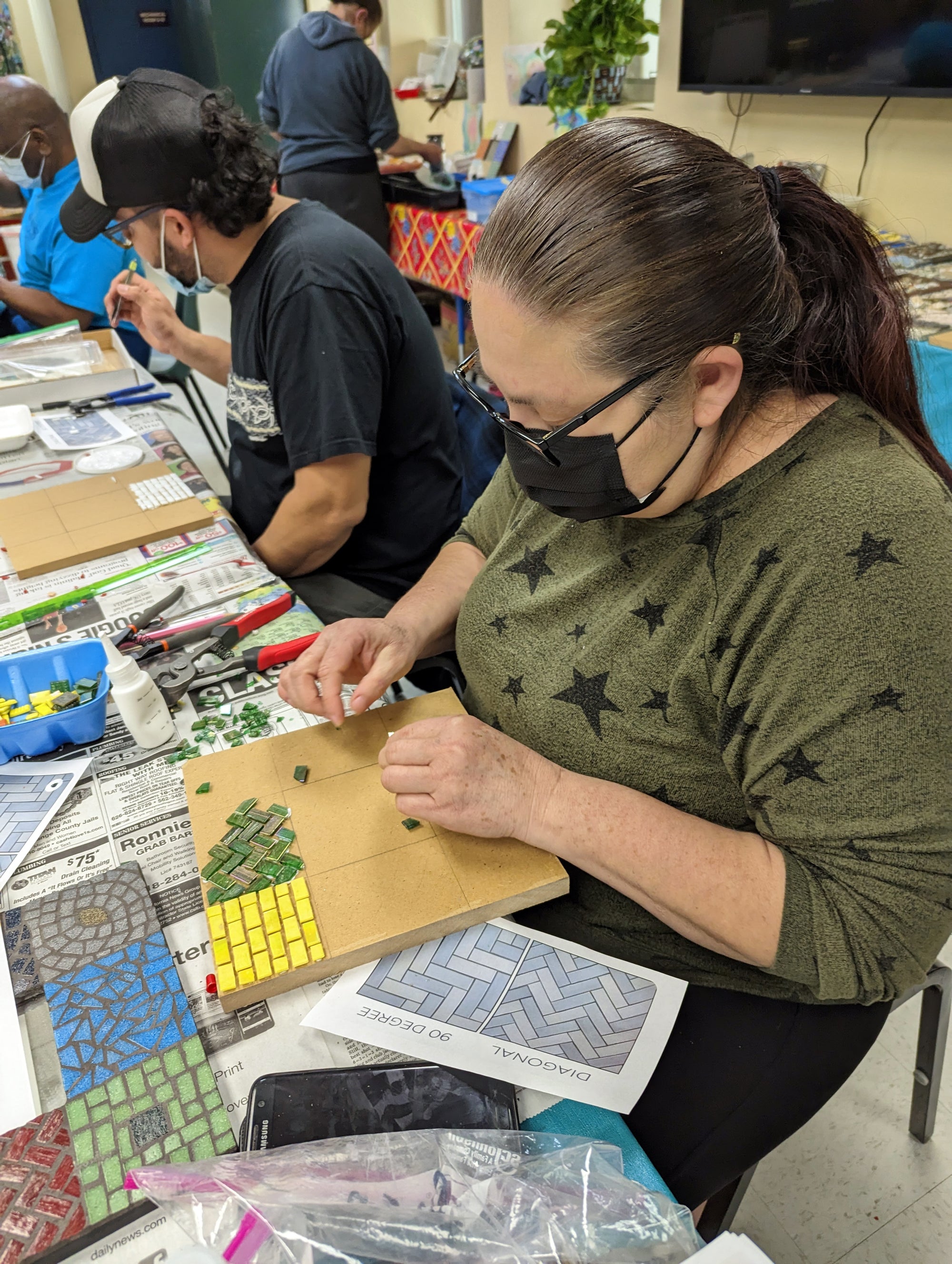 Artist working on a mosaic at a Piece by Piece workshop.