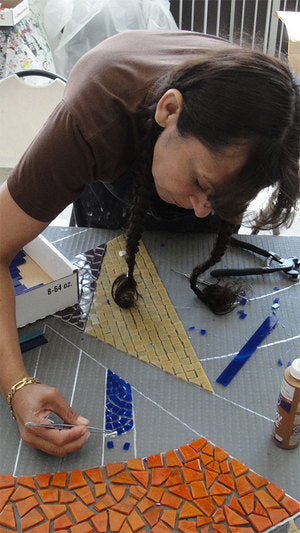 Artist working on a large mosaic at a Piece by Piece Workshop