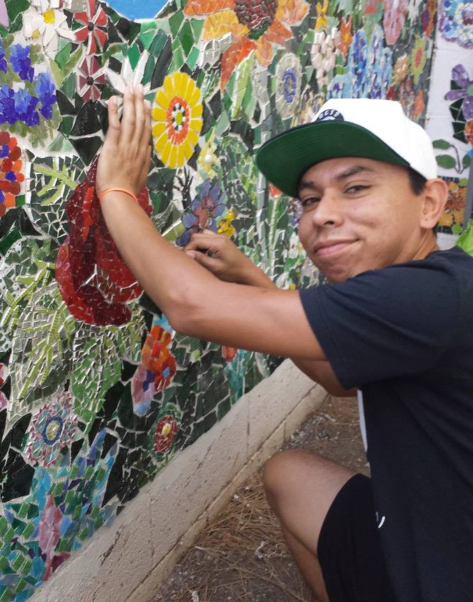 Community member working on Broadway's Blooming mosaic wall.
