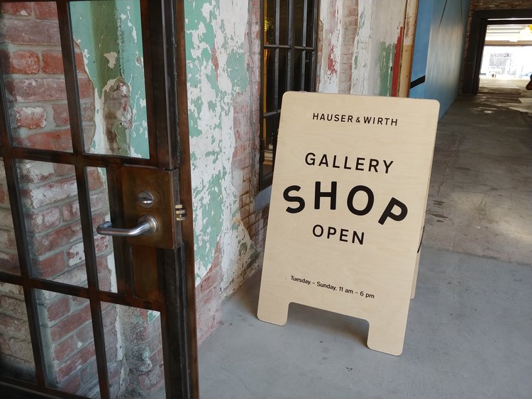 A-frame sign in front of Hauser and Wirth store that says "Gallery Shop Open"