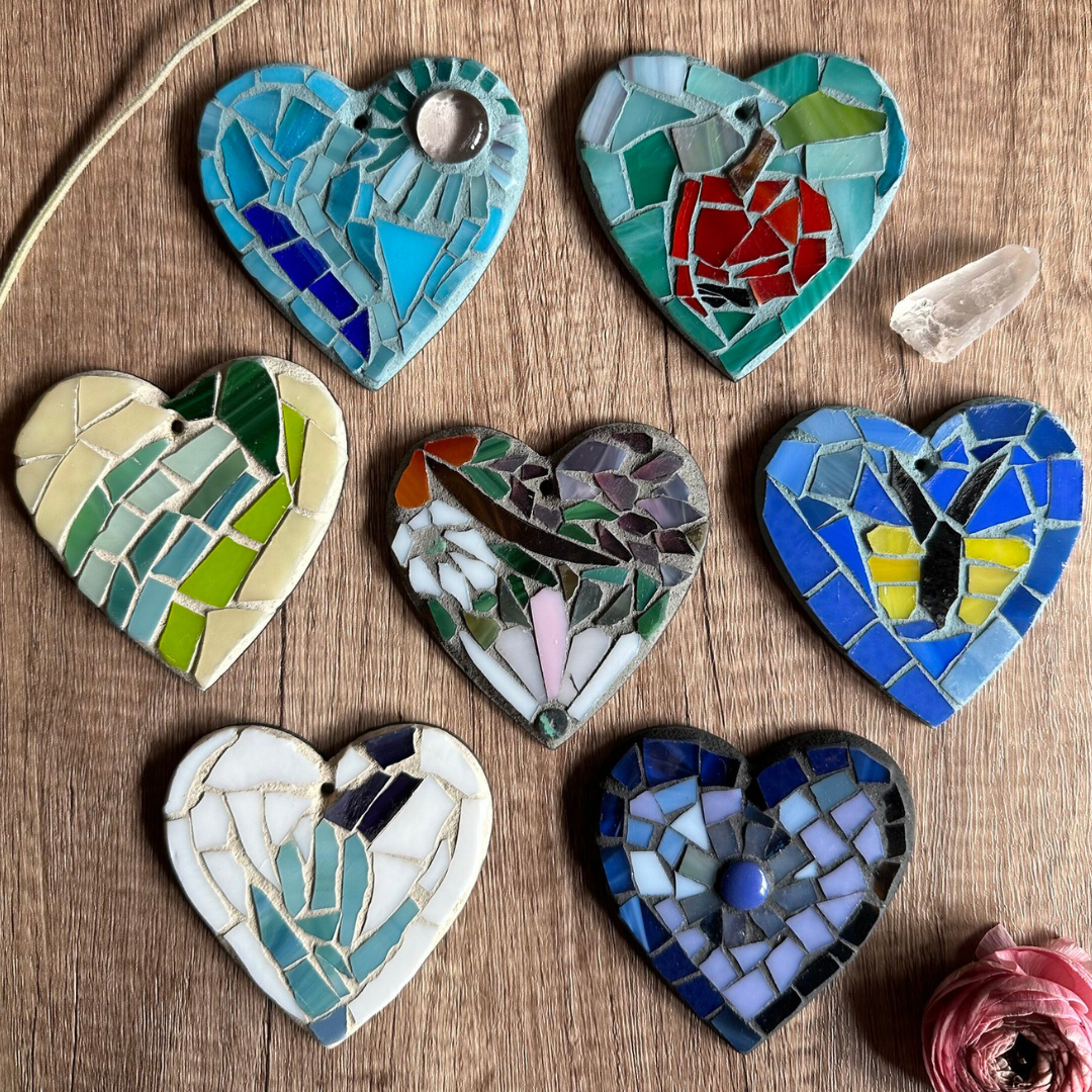 Seven mosaic heart-shaped ornaments with varying designs and colors.
